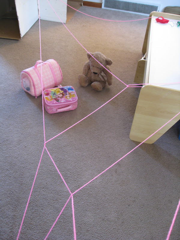 Spiderweb obstacle course with pink yarn