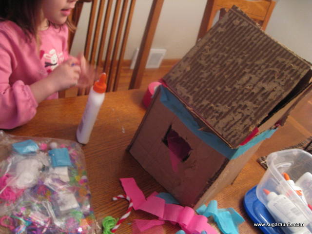 Kids can make a gingerbread house with craft materials.