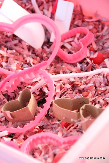 Make a shredded paper sensory bin with hearts made from toilet paper tubes.