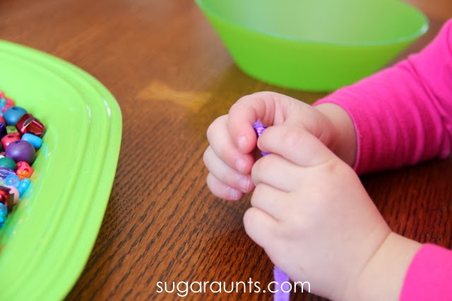 Manipulating beads on pipe cleaners is a great fine motor activity for toddlers
