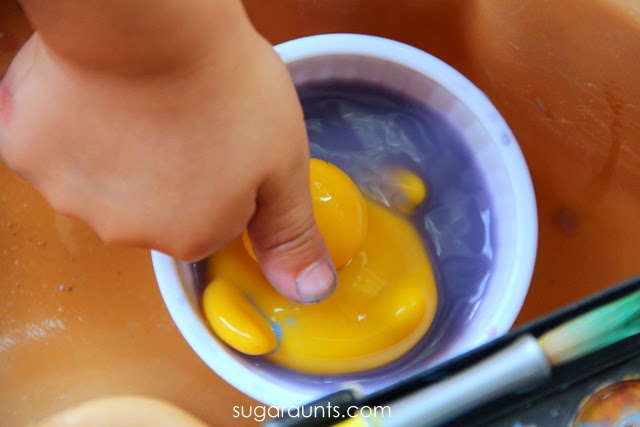 Sensory play to wash the paint off the rubber duck toys