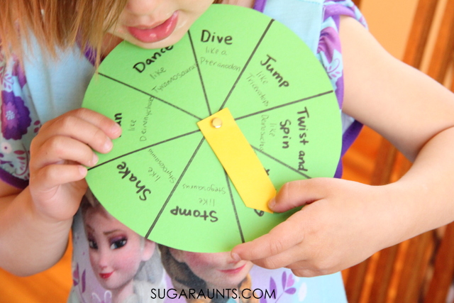Child spinning a game spinner with words like dive, jump, twist, spin, shake, stomp like dinosaurs.