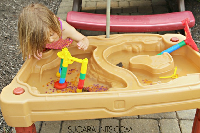 Actividad en la mesa de agua para niños: ¡utiliza una canica y cuentas de agua para recoger y verter la motricidad fina y la diversión sensorial este verano!