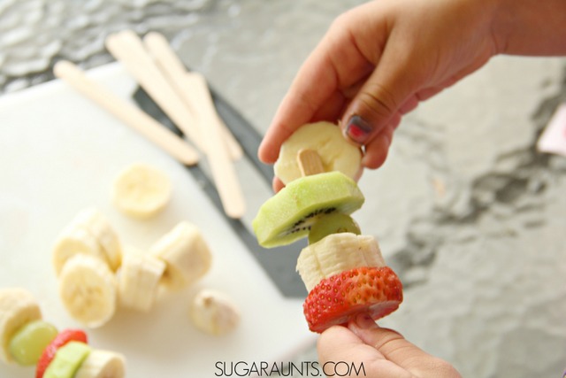 Frozen Fruit Kabob treat.  Kids love to make and eat these frozen treats! So much healthier than sugary popsicles. Perfect for summer snacks and cooking with kids!