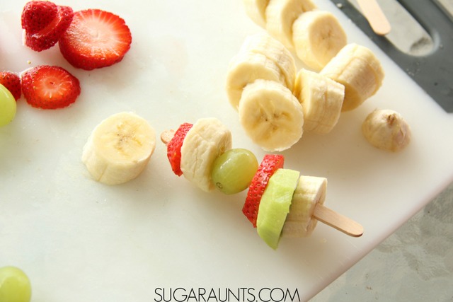 Frozen Fruit Kabob treat.  Kids love to make and eat these frozen treats! So much healthier than sugary popsicles. Perfect for summer snacks and cooking with kids!