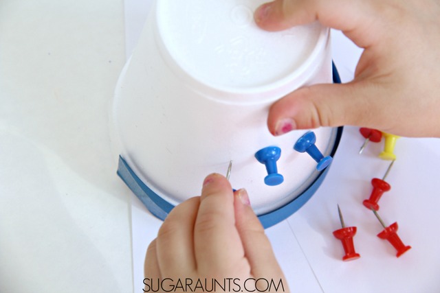 Fine motor color math with push pins and a foam cup. This is great and a simple activity for preschoolers to do at home! Work on counting, addition, subtraction, and color recognition with materials you already have at home (free or almost free materials for homeschool or learning extension activities at home!)