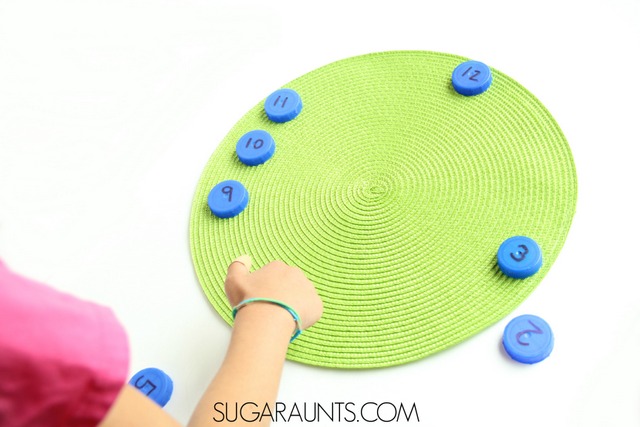 Teach kids how to tell time with hands on learning in this first grade or second grade time telling activity using recycled bottle caps.  Build a clock and practice telling time!