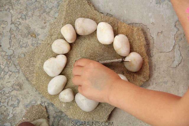 Aprenda con las piedras, incluyendo la enseñanza de los niños a decir la hora, las matemáticas, la alfabetización, la motricidad fina, la sensorialidad.