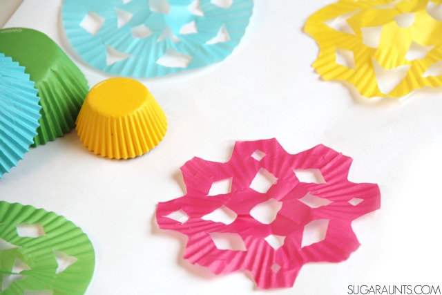 Practice scissor skills and provide proprioception with this miniature cupcake liner snowflakes craft for kids.