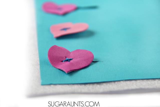 Teach kids how to button with this easy DIY buttoning teaching tool for fine motor practice and play, with hearts. Perfect for Valentine's Day