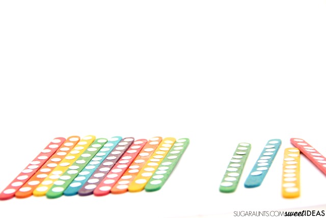 Haz un rompecabezas de centenas usando palitos de paleta de arco iris para las matemáticas multisensoriales para niños.