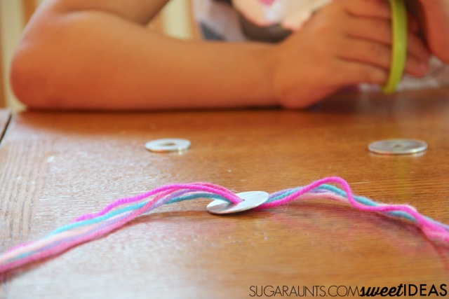 Utiliza hilo y arandelas para crear divertidas joyas en este proceso creativo de arte para niños.  