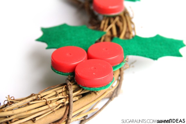 Make this bottle caps holly craft using recycled bottle caps for a fun Christmas tree holly ornament, a gift topper, or a holiday wreath.