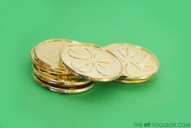 Plastic gold coins (or regular coins) are a great tool for improving hand strength and fine motor skills in kids.