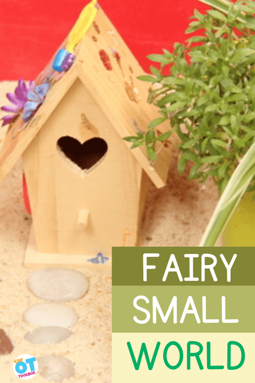 Wooden birdhouse decorated with flowers, glitter, and beads, in a sandbox with small steps made from pebbles. Text reads fairy small world